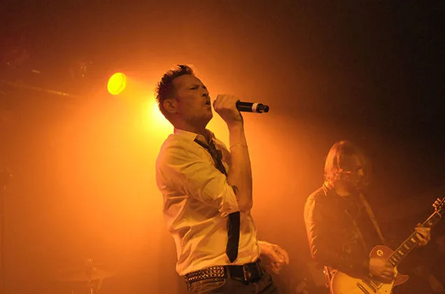 Ο Scott Weiland τραγουδάει σε σκηνή με έντονο πορτοκαλί φωτισμό