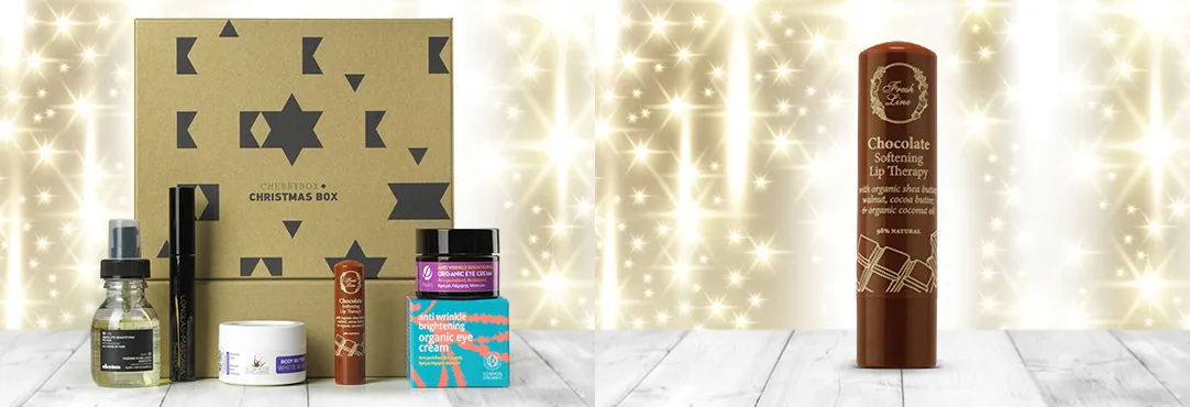 Σετ καλλυντικών Cherrybox Christmas Box και Lip Therapy σε εορταστικό φόντο.