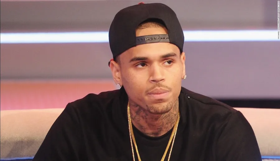 Ο Chris Brown με μαύρο καπέλο και χρυσές αλυσίδες.