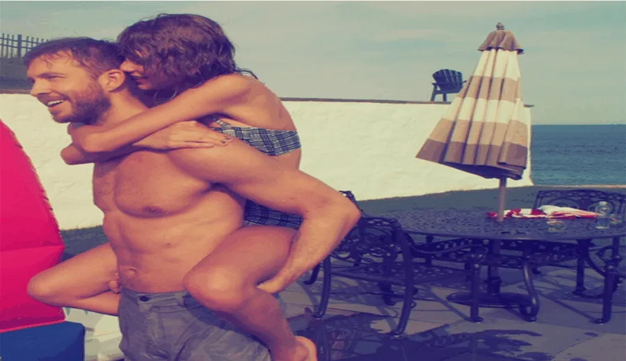 Ο Calvin Harris κουβαλάει στην πλάτη του την Taylor Swift σε εξωτερικό χώρο.