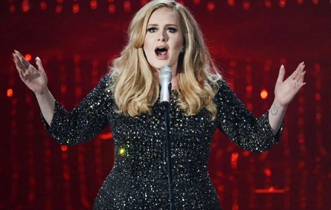 Η Adele τραγουδάει στη σκηνή με μαύρο φόρεμα με παγιέτες
