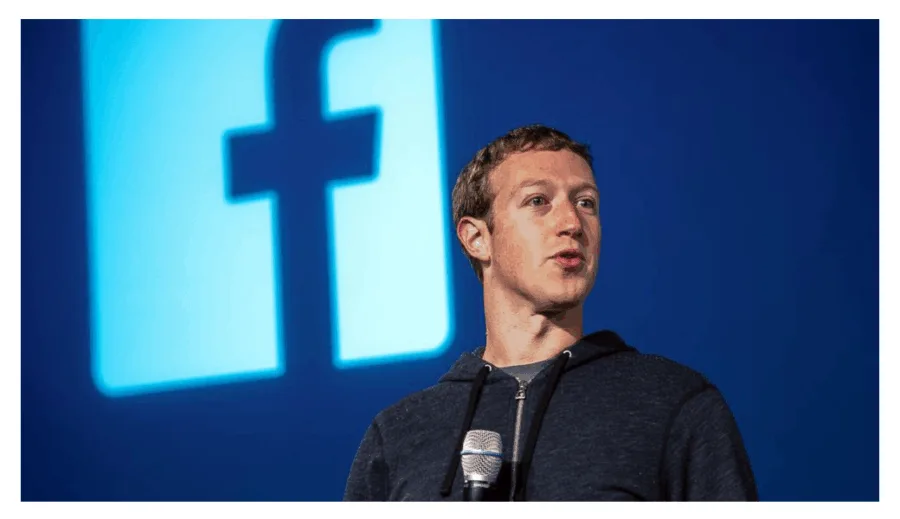 Ο Mark Zuckerberg μιλάει σε εκδήλωση με το λογότυπο του Facebook στο φόντο.