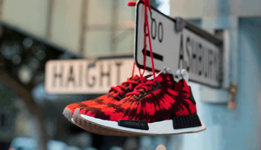 Τα sneakers NMD Runner PK Nice Kicks κρεμασμένα σε πινακίδα οδού στο Σαν Φρανσίσκο.