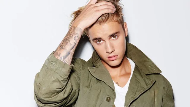 Ο Justin Bieber με χακί τζάκετ και τατουάζ στο χέρι.