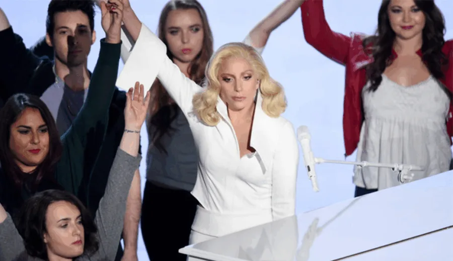 Η Lady Gaga στη σκηνή των Oscars 2016 με μια ομάδα ανθρώπων.