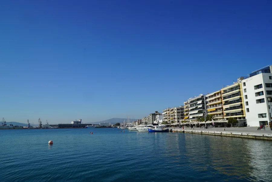 Άποψη του λιμανιού του Βόλου με σκάφη και κτίρια στην παραλία.