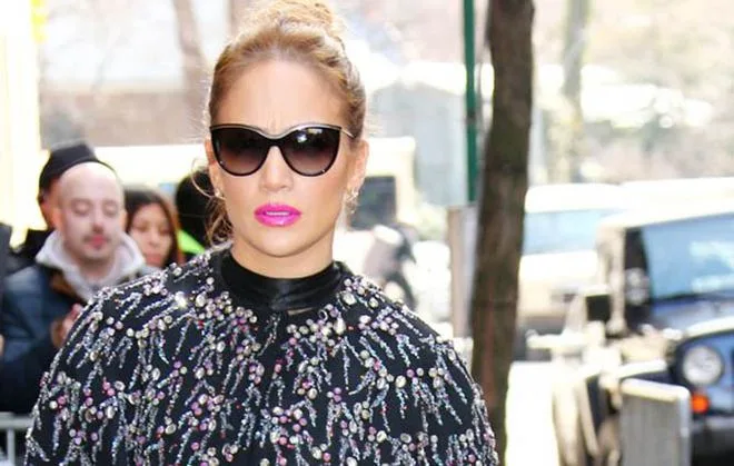 Η Jennifer Lopez με γυαλιά ηλίου και εντυπωσιακό μαύρο ρούχο με κεντήματα.