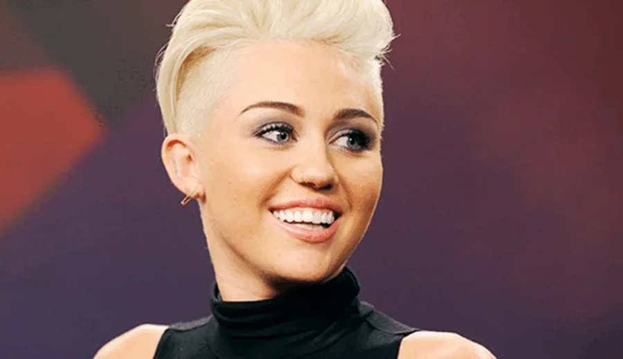 Η Miley Cyrus με κοντό ξανθό μαλλί και μαύρο ζιβάγκο.