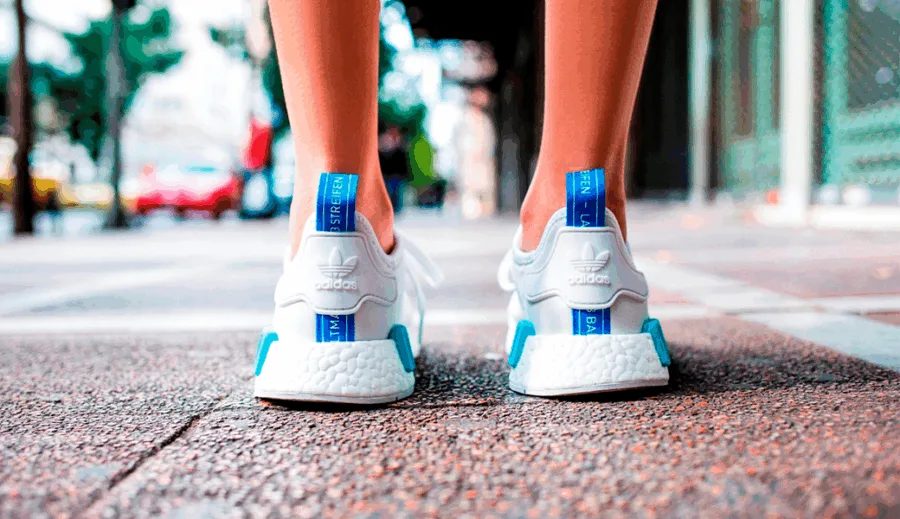 Κοντινό πλάνο στα λευκά παπούτσια Adidas NMD από πίσω, σε δρόμο της Αθήνας.
