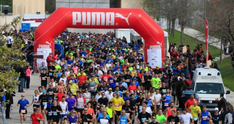 Πλήθος δρομέων κάτω από φουσκωτή αψίδα Puma στον Ημιμαραθώνιο Μαραθώνα.