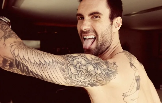 Ο Adam Levine ποζάρει δείχνοντας τα τατουάζ στο χέρι και την πλάτη του.