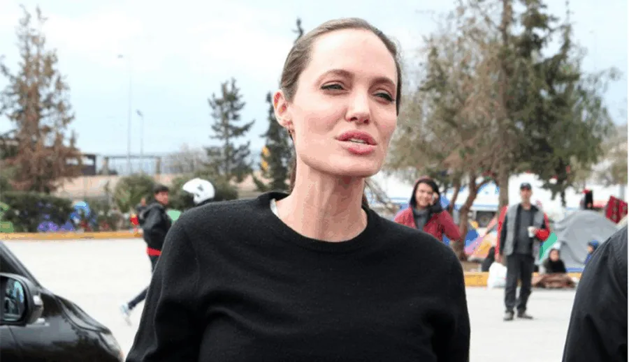 Η Angelina Jolie σε εξωτερικό χώρο με κόσμο στο βάθος.
