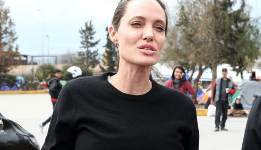 Η Angelina Jolie σε εξωτερικό χώρο με κόσμο στο βάθος.