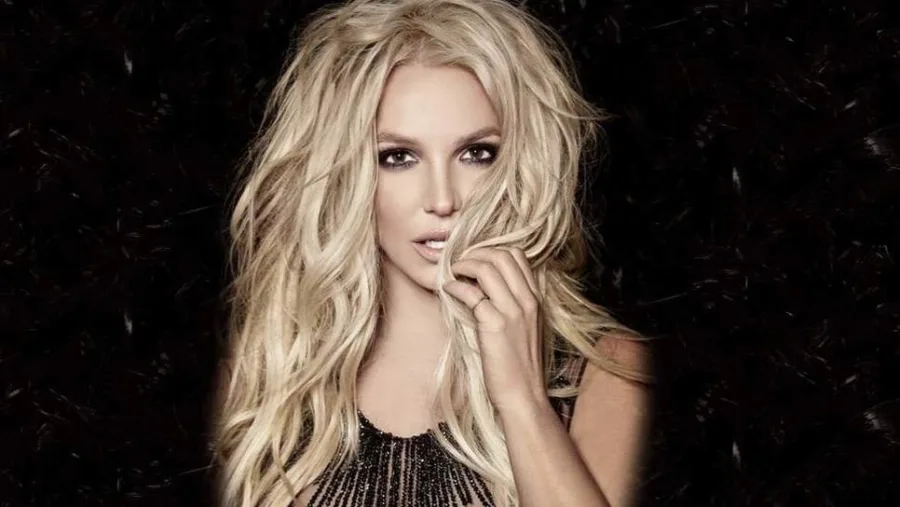 Η Britney Spears σε κοντινό πλάνο με ξανθά μαλλιά και μαύρο φόντο.