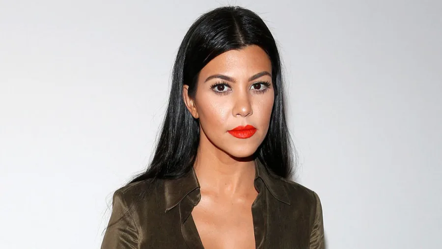 Η Kourtney Kardashian με σκούρο πράσινο πουκάμισο και κόκκινο κραγιόν.
