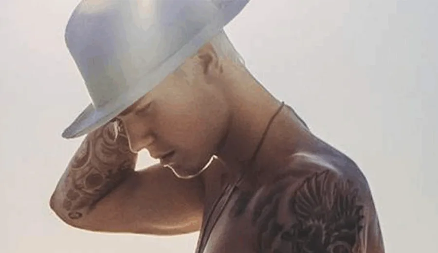 Ο Justin Bieber με λευκό καπέλο και τατουάζ στο στήθος και το χέρι.