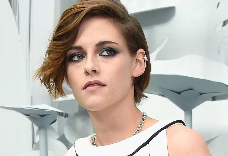 Κοντινό πλάνο της Kristen Stewart με κοντό καστανό μαλλί και έντονο μακιγιάζ ματιών.