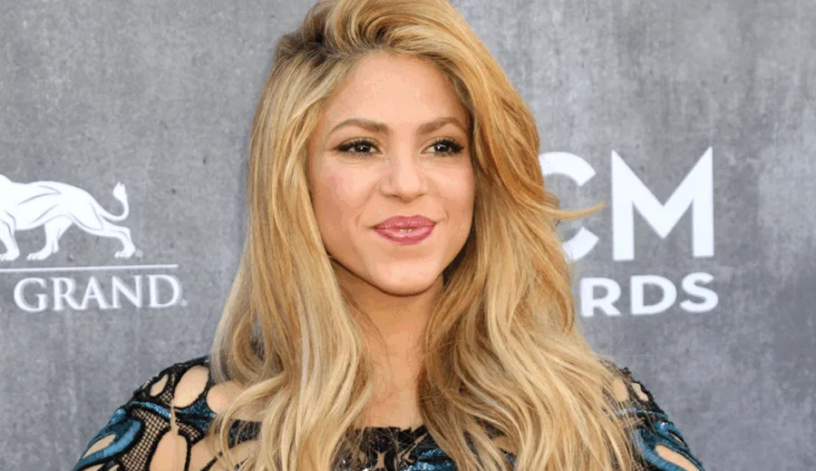 Η Shakira σε επίσημη εμφάνιση με ξανθά μαλλιά και μαύρο δαντελωτό φόρεμα.