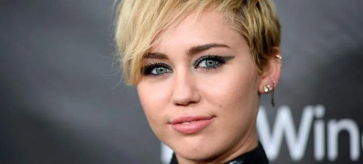 Κοντινό πλάνο της Miley Cyrus με ξανθό κοντό κούρεμα.