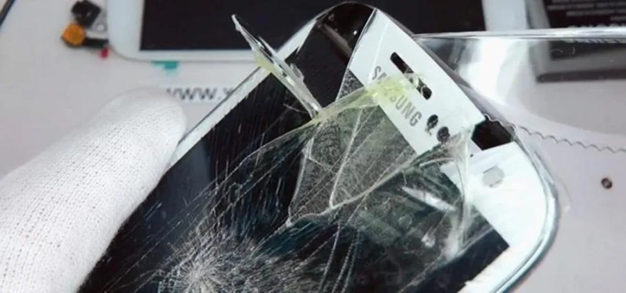 Σπασμένη οθόνη κινητού τηλεφώνου Samsung με εμφανή ραγίσματα και αποκόλληση του γυαλιού.