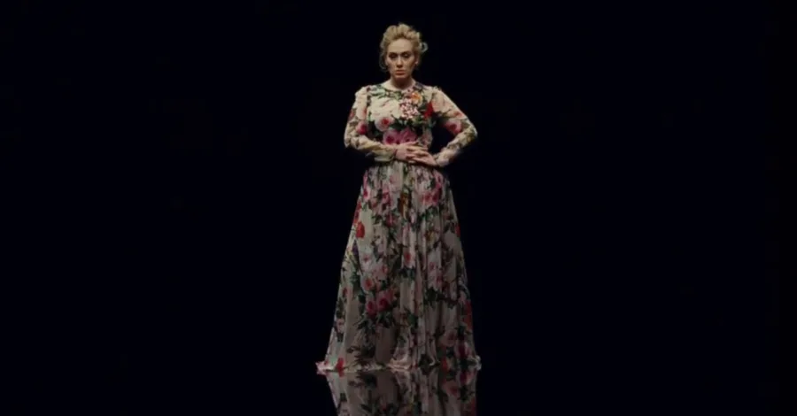 Η Adele με φλοράλ φόρεμα σε μαύρο φόντο από το βίντεο κλιπ Send My Love (To Your New Lover).