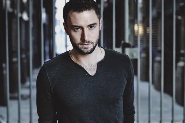 Ο Mans Zelmerlow κοιτάζει την κάμερα φορώντας γκρι μπλούζα.