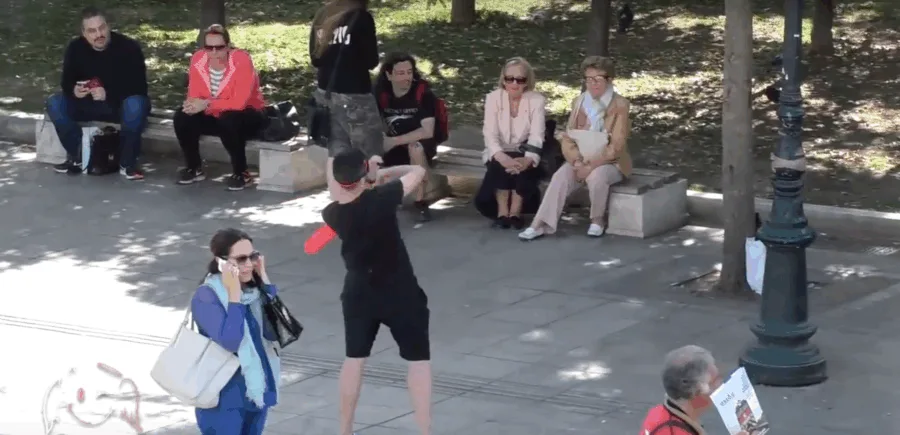 Μέλος των Astathios Pranks κάνει φάρσα με κόκκινο μπαλόνι σε πλατεία.
