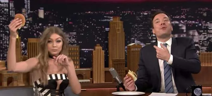 Η Gigi Hadid και ο Jimmy Fallon τρώνε burger στο πλατό της εκπομπής The Tonight Show.