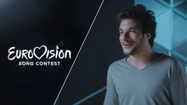 Ο Amir δίπλα στο λογότυπο της Eurovision Song Contest.