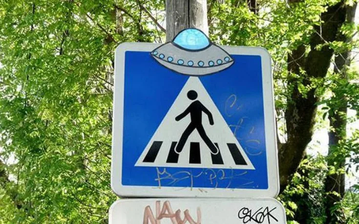 Πινακίδα διάβασης πεζών με αυτοκόλλητο UFO.