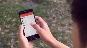Χρήστης κρατάει smartphone με εφαρμογή της Google σε εξωτερικό χώρο.