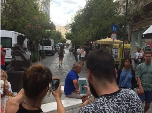 Άνθρωποι σε δρόμο της Αθήνας κρατούν κινητά τηλέφωνα παίζοντας Pokemon Go.
