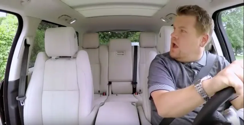Ο James Corden οδηγεί αυτοκίνητο κοιτάζοντας έκπληκτος προς το κενό κάθισμα του συνοδηγού.