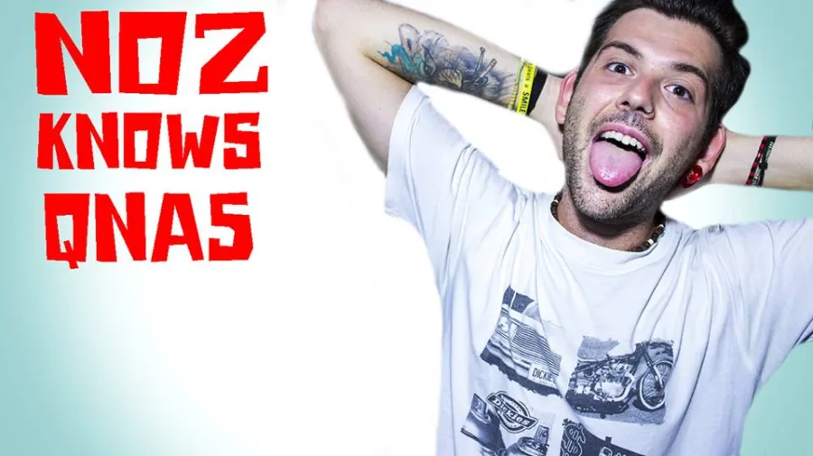 Νεαρός άνδρας με τατουάζ και λευκό t-shirt ποζάρει με τη γλώσσα έξω δίπλα στο κείμενο NOZ KNOWS QNAS.