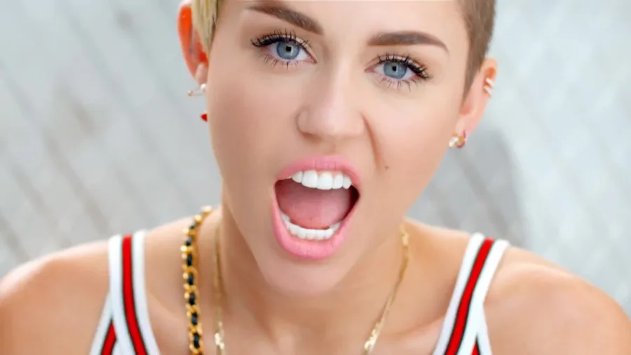Κοντινό πλάνο της Miley Cyrus με κοντό ξανθό μαλλί και ανοιχτό το στόμα.