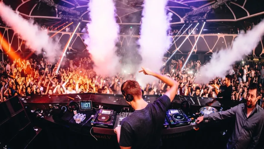 Ο DJ Calvin Harris σε εμφάνιση σε γεμάτο club με εφέ καπνού.