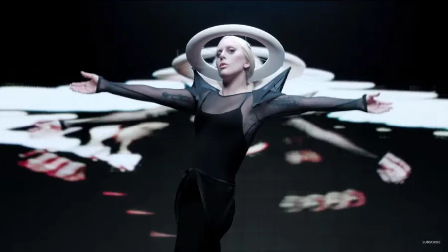 Η Lady Gaga με φουτουριστικό μαύρο κορμάκι και λευκό δακτύλιο στο κεφάλι.
