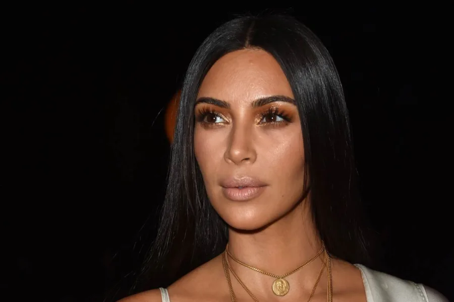 Κοντινό πορτρέτο της Kim Kardashian με χρυσή σκιά ματιών και μακριά μαύρα μαλλιά.
