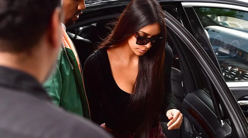 Η Kim Kardashian βγαίνει από ένα μαύρο αυτοκίνητο φορώντας μαύρη μπλούζα και γυαλιά ηλίου.