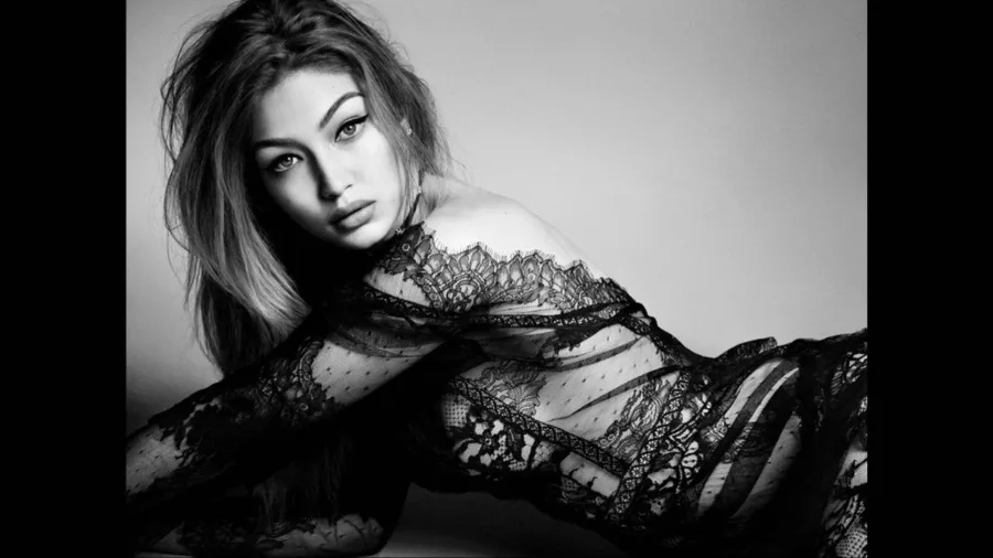 Η Gigi Hadid ποζάρει με μαύρο δαντελωτό ρούχο σε ασπρόμαυρη φωτογραφία.