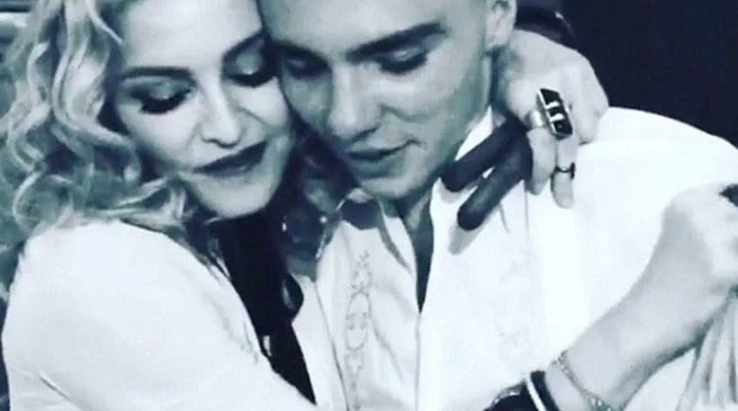 Η Madonna αγκαλιάζει τον γιο της Rocco Ritchie σε ασπρόμαυρη φωτογραφία.