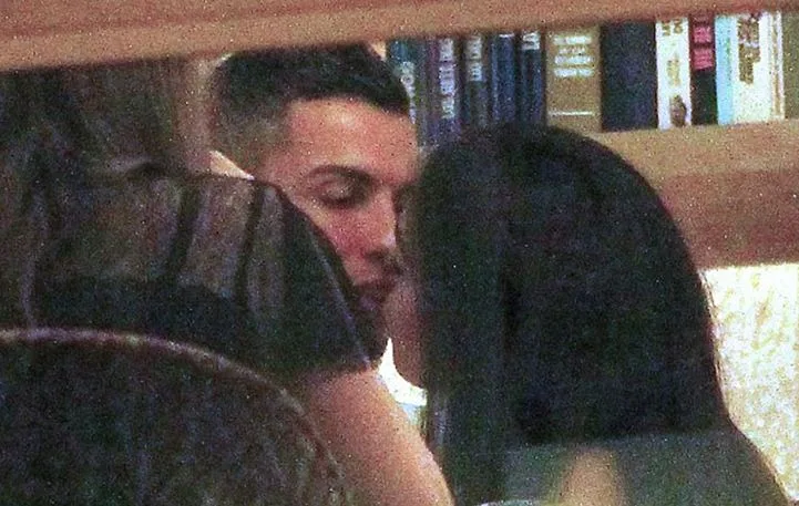 Ο Cristiano Ronaldo και η Georgina Rodriguez ανταλλάσσουν ένα φιλί σε εστιατόριο.