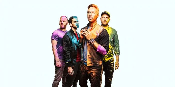 Το συγκρότημα Coldplay ποζάρει καλυμμένο με πολύχρωμες σκόνες.
