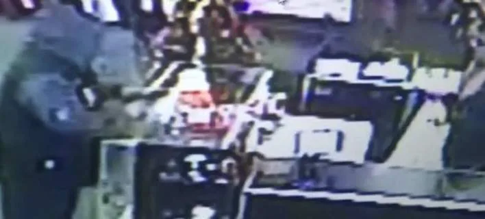 Στιγμιότυπο από κάμερα ασφαλείας κατά τη διάρκεια ληστείας σε κατάστημα.