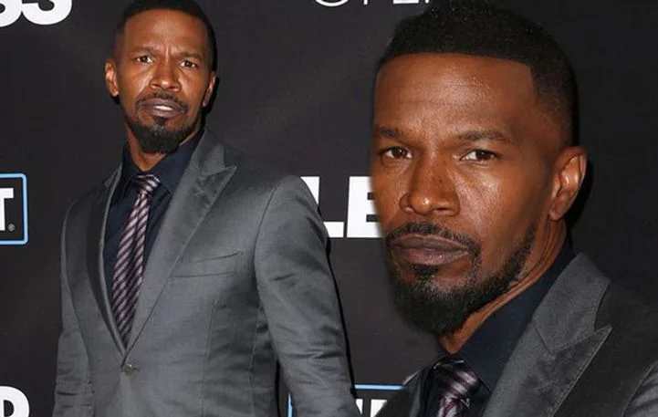 Ο Jamie Foxx με γκρι κοστούμι και ριγέ γραβάτα.