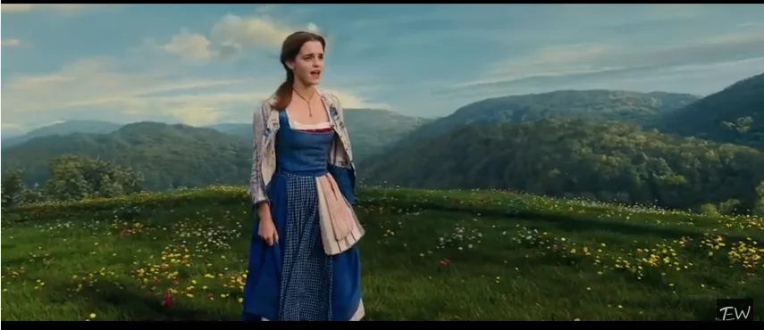 Η Emma Watson ως Belle στην ταινία Beauty and the Beast σε ένα καταπράσινο λιβάδι.