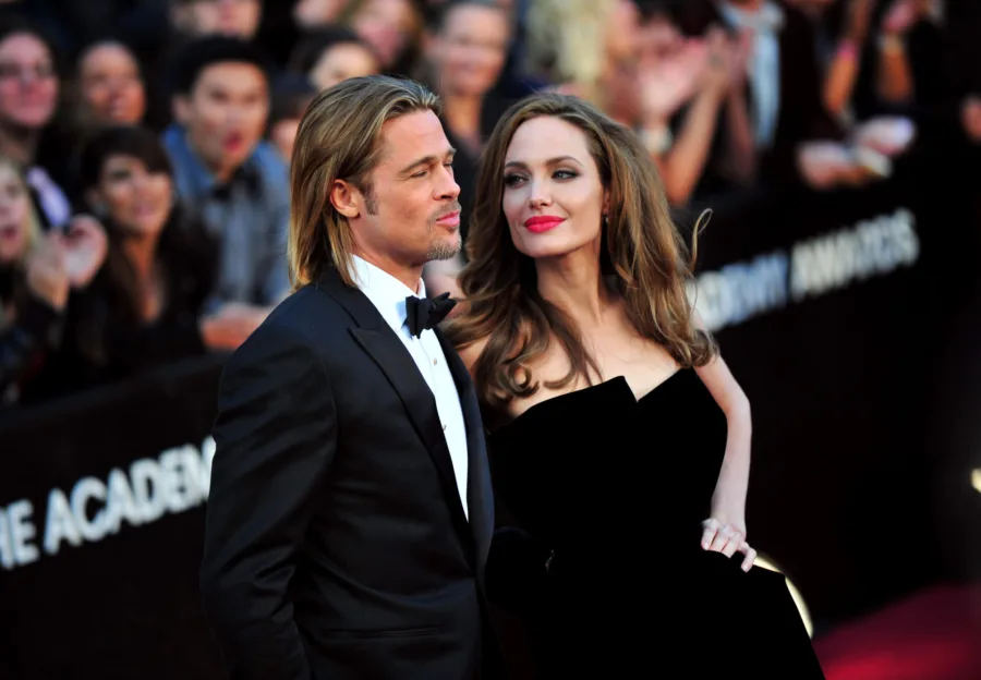 Ο Brad Pitt και η Angelina Jolie σε βραδινή εμφάνιση, με φόντο το κόκκινο χαλί και την ανακοίνωση για την έπαυλη.