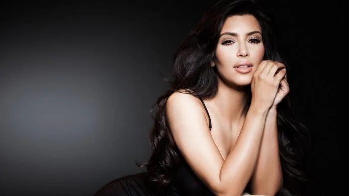 Η Kim Kardashian ποζάρει σε σκούρο φόντο.