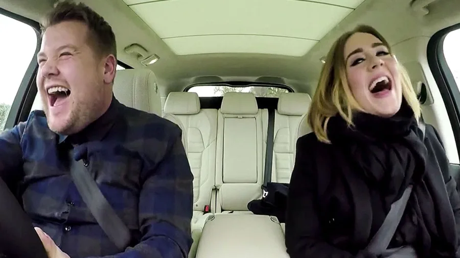 Ο James Corden και η Adele γελάνε μέσα σε ένα αυτοκίνητο κατά τη διάρκεια του Carpool Karaoke.