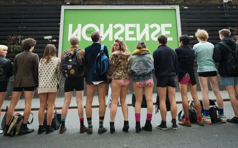 People pose for a photograph before taking part in the annual "No Trousers On The Tube Day" event in central London on January 11, 2015. Originally started in the US, the international event, also known as the "No Pants Subway Ride" was created by improvisation group "Improv Everywhere" and sees people taking train journies while wearing no trousers, yet acting as normally as possible. AFP PHOTO / LEON NEAL